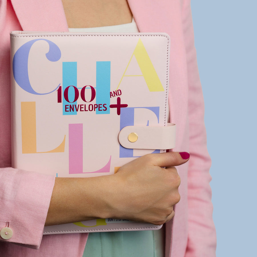 Woman holding the pink 100 Envelopes Challenge binder